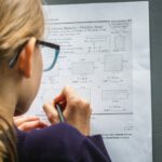 woman in black framed eyeglasses holding pen